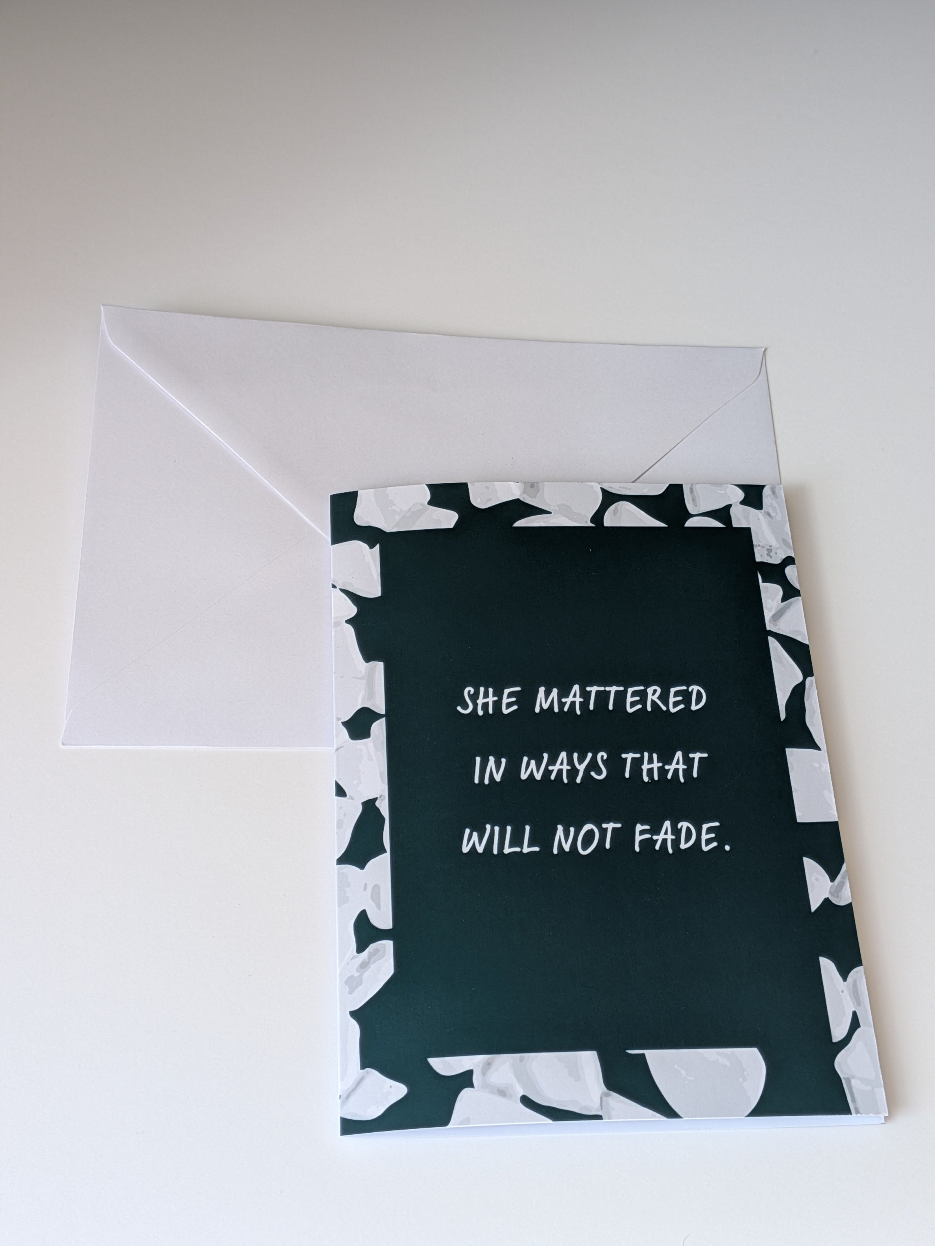 Greeting card with text 'She mattered in ways that will not fade' on a white background